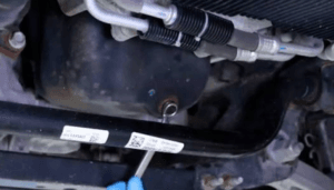 The drain plug sits toward the rear of the pan on most 5.7L HEMI trucks.